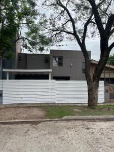 einen weißen Zaun vor einem Haus in der Unterkunft Casa Cerro de las Rosas in Cordoba