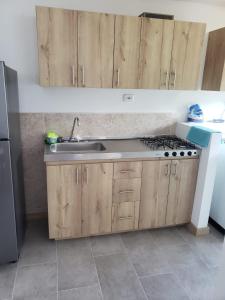 a kitchen with wooden cabinets and a sink and a stove at cómodo apartamento en Copacabana in Copacabana