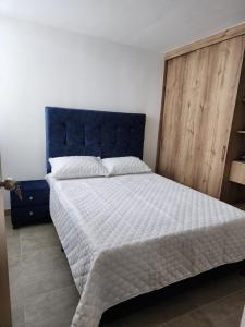 a bedroom with a large bed with a blue headboard at cómodo apartamento en Copacabana in Copacabana