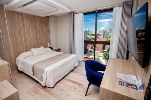 a hotel room with a bed and a large window at Hotel Sirari By Regina in Santa Cruz de la Sierra