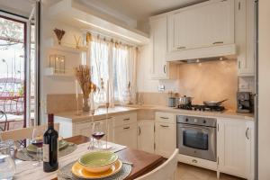 una cocina con armarios blancos y una mesa con una botella de vino en Corso Emanuele Apartments, en San Vincenzo