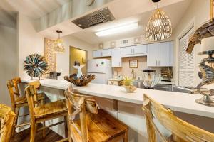 a kitchen with a large white counter and chairs at Patio Paradise in Panama City Beach