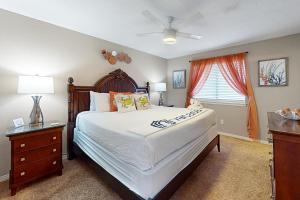 Un dormitorio con una cama grande y una ventana en Patio Paradise, en Panama City Beach