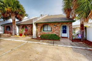 een stenen huis met palmbomen ervoor bij Patio Paradise in Panama City Beach