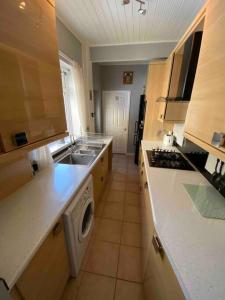a kitchen with a sink and a washing machine at East Stay 2/3 bedroom Flat in Westoe