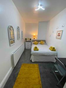 een slaapkamer met een bed met gele handdoeken erop bij East Stay 2/3 bedroom Flat in Westoe