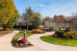 a walkway in a garden with a table and flowers at Courtyard Wall at Monmouth Shores Corporate Park in Wall Township