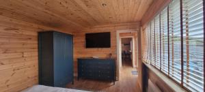 a wooden room with a television and a dresser at The Wellsprings Lodges and Restaurant in Clitheroe