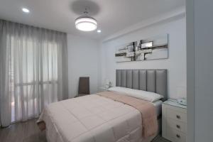 Habitación blanca con cama y ventana en Apartamento Sunset 365-Rentals, en Torre del Mar