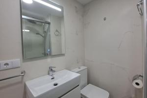 y baño con lavabo, aseo y espejo. en Apartamento Sunset 365-Rentals, en Torre del Mar