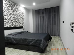 1 dormitorio con cama negra y ventana en Apartment VOX, en Batumi