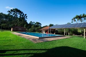 einen Pool in einem Garten mit Sonnenkollektoren in der Unterkunft pousada do caneca in Senador Amaral