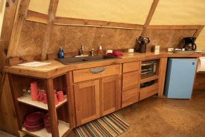 a kitchen with a sink and a refrigerator at Rising Moon - Tipi 8 in Fourth Crossing