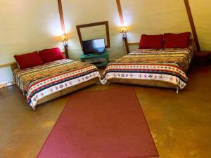 duas camas sentadas uma ao lado da outra num quarto em Sitting Bull - Tipi 6 em New Braunfels