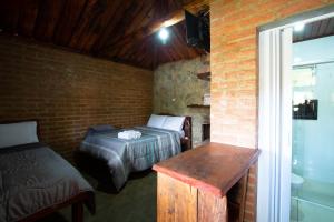 Schlafzimmer mit einem Bett, einem Tisch und einem Fenster in der Unterkunft pousada do caneca in Senador Amaral
