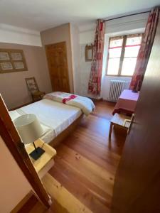 a small bedroom with two beds and a window at Chez Agathe au Chalet de segure in Ristolas