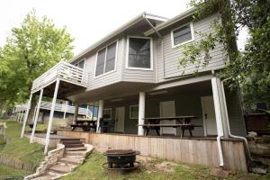a house with a porch with a picnic table and a grill at Air Haus in Fourth Crossing