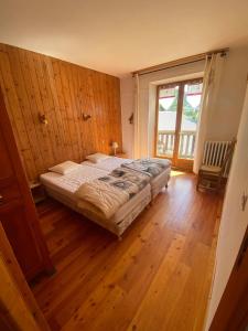 ein Schlafzimmer mit einem Bett in einer Holzwand in der Unterkunft Chez Izaline au Chalet de segure in Ristolas