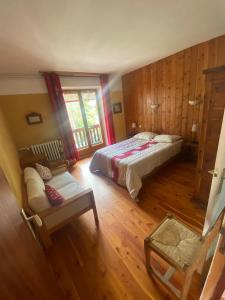 ein Schlafzimmer mit einem Bett und einem Sofa darin in der Unterkunft Chez Izaline au Chalet de segure in Ristolas