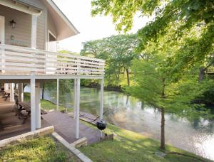 a house with a deck next to a river at Air Haus LITE in Fourth Crossing