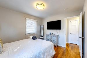 - une chambre avec un lit blanc et une télévision à écran plat dans l'établissement City Sanctuary, à Atlanta