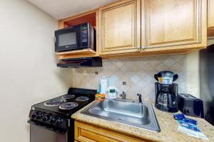eine Küche mit einer Spüle und einer Mikrowelle in der Unterkunft Compass Cove 655 in Myrtle Beach