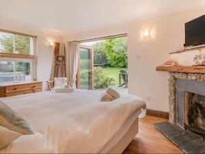 a bedroom with a large bed and a fireplace at Clotted Cream Cottage: Countryside calm: Close to beach: Dartmouth: Devon in Dartmouth