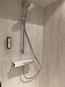 a shower with a shower head on a wall at Loft Krämerhaus Annaberg, Dachstein West in Annaberg im Lammertal