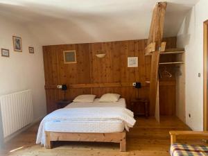 1 dormitorio con 1 cama en una habitación con paredes de madera en Chez Bérangère au Chalet de segure, en Ristolas