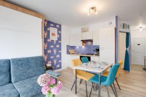 a living room with a blue couch and a table at Gîte du Pêcheur in Lézardrieux