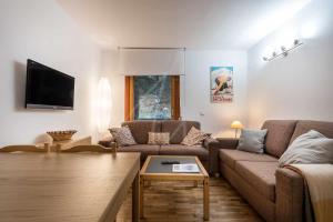 a living room with a couch and a tv at Bonaigua 006 by SeaMount Rentals in Naut Aran