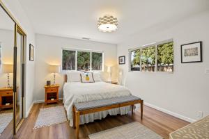 a bedroom with a bed and two windows at Hummingbird Haven in Santa Barbara