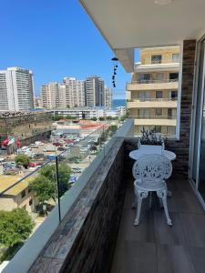a balcony with a table and a view of a city at Arriendo Departamento 10 Norte Viña del Mar in Viña del Mar