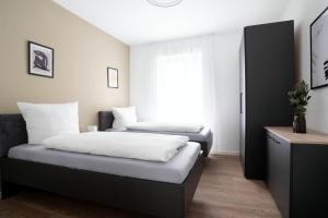 a bedroom with two beds and a window at Schicke Apartments in Osnabrück I private Parkplätze I home2share in Osnabrück