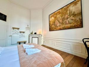 una camera con un letto e un dipinto sul muro di Champagne des Anges - Proche Cathédrale de Reims a Reims