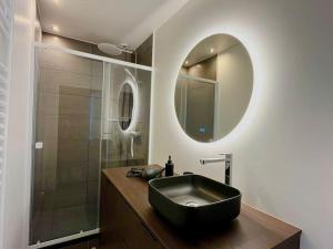 un bagno con un lavandino nero e una doccia di Champagne des Anges - Proche Cathédrale de Reims a Reims Altre 15 foto