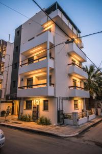 un edificio de apartamentos blanco con luces encendidas en Nestia urban apartments, en Volos