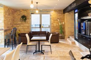 a restaurant with a table and chairs in a room at Le Relais de la Poste in Gourdon