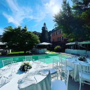 a table set up for a wedding in front of a pool at Hotel Milano Pool & Garden in Salice Terme
