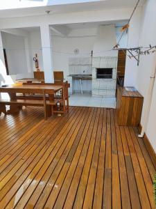 Habitación grande con mesa de madera y cocina. en Casas do juju, en Palhoça