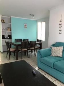 uma sala de estar com um sofá azul e uma mesa em Arriendo de verano, La Serena 2024 em La Serena