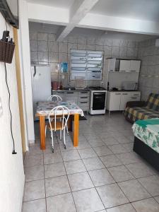 uma cozinha com mesa e cadeiras num quarto em Casas do juju em Palhoça