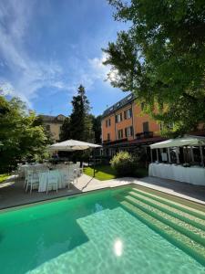 a swimming pool with a table and chairs at Hotel Milano Pool & Garden in Salice Terme