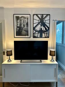 a flat screen tv sitting on top of a white cabinet at Cosy Central London Apartment in London