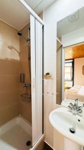 uma casa de banho com um lavatório e um chuveiro em Sé Velha Suites em Coimbra