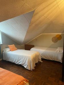 two beds in a room with a roof at Rouge Cottage nel Roero in Sanfrè