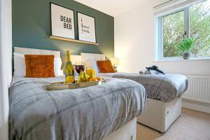 a bedroom with two beds with a tray of food and drinks at Stylish City Centre Apartment with Free Parking, Fast W-fi, Smart TV and Balcony by Yoko Property in Chelmsford
