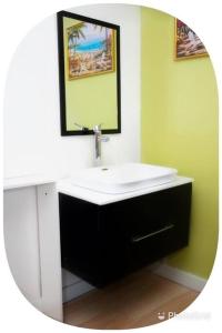 a bathroom with a white sink and a mirror at Cocoplum Rest N Hideaway #2 in Nassau