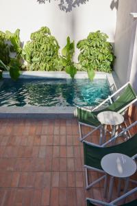 a swimming pool with two chairs and a table at ANTIPODA HOTEL Boutique in Medellín