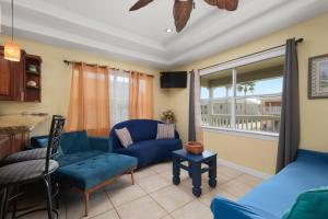 een woonkamer met een blauwe bank en een stoel bij Spacious 10 Bed, Steps to Beach, Private Pool, Yard, Grill in South Padre Island